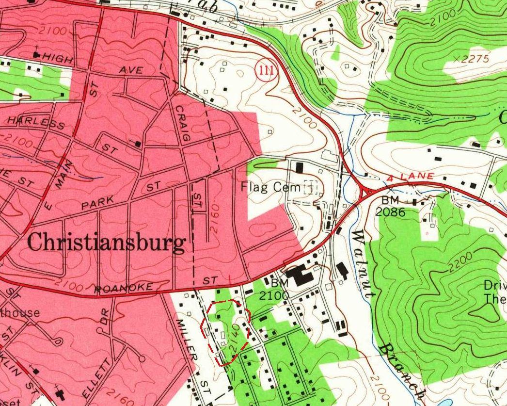 Detail of a 1965 topographic map: the pink built-up area of Christiansburg with Roanoke Street and Miller Street, a small dashed red outline on a green wooded knoll marked 2140, and a grid of streets with black house squares to the east.